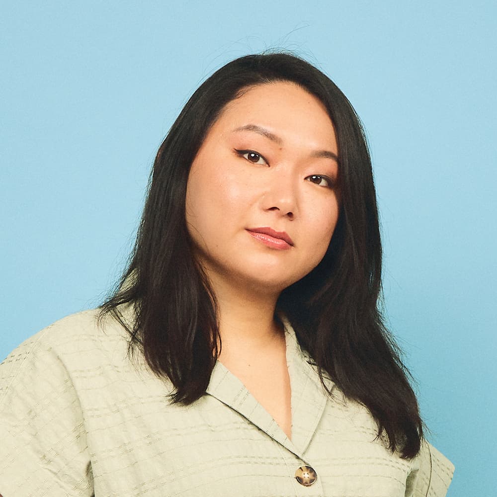 A long haired Asian woman on top of a light blue background